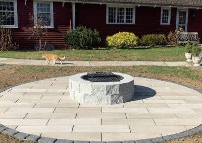 Haverhill, MA Patio with Granite Fire Pit: Professional hardscape and outdoor design service in Haverhill, Massachusetts, featuring a beautifully designed patio with a stunning granite fire pit.