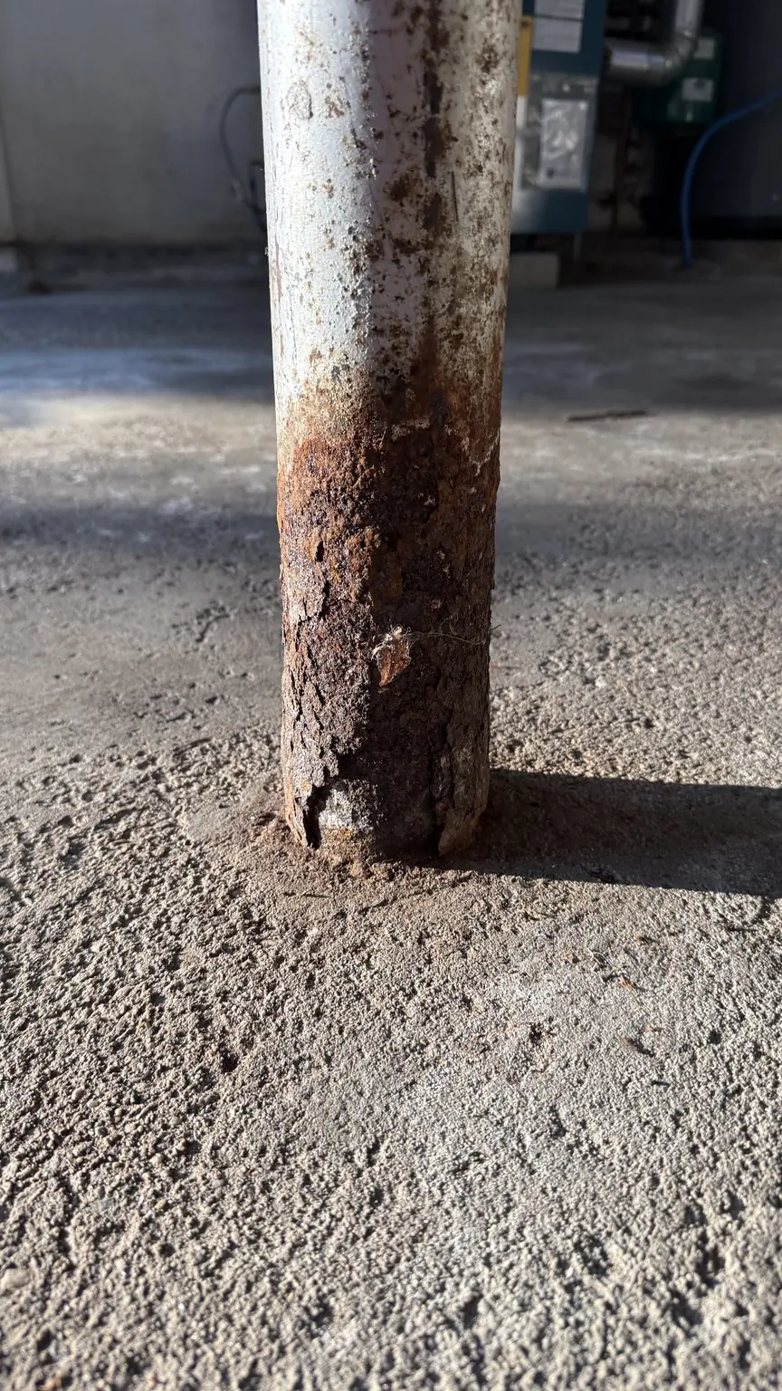 Severe corrosion and steel deterioration at the base of a basement Lally column