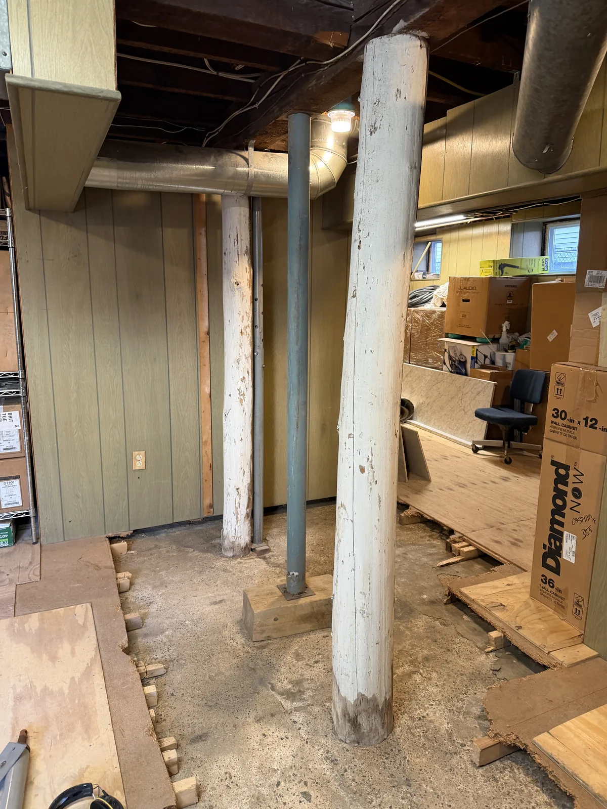 Existing wood basement posts beside adjustable steel supports